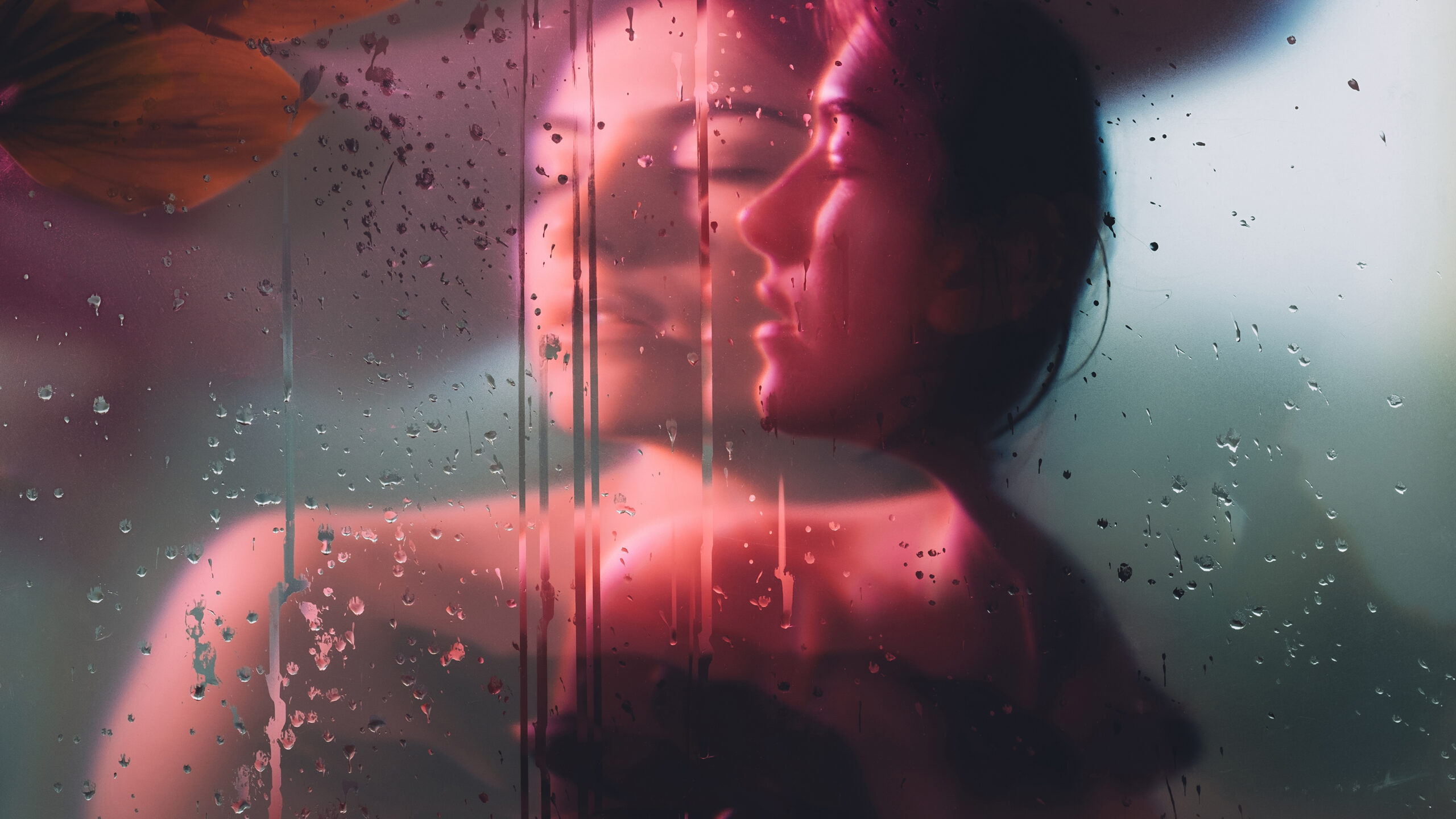 A woman’s profile seen through rain-streaked glass, colours bleeding like a double exposure